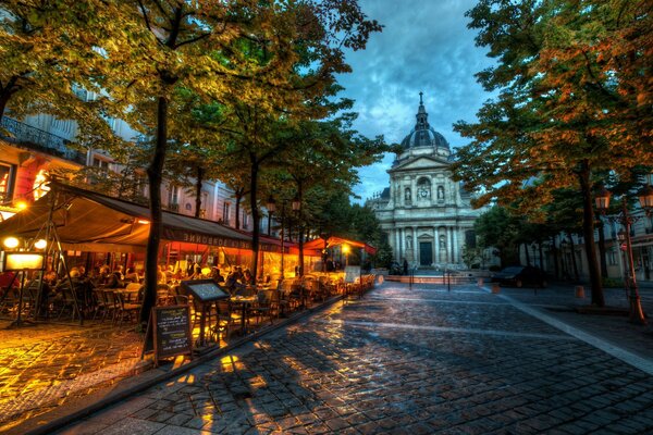 A restaurant in the light of lanterns under a twilight sky