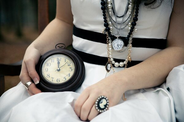 An adult woman in a white dress with a watch on her lap