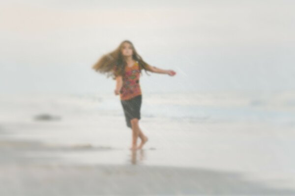 一个女孩在沙滩上的海浪上运行