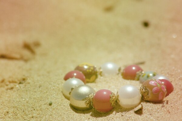 A pearl bracelet thrown on the sand