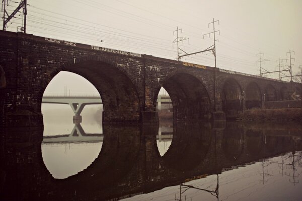 Stone bridge over water with reflection