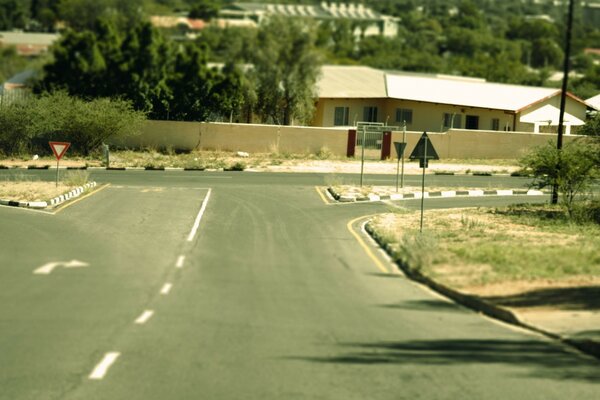 A sunny illuminated road in a sparsely populated area