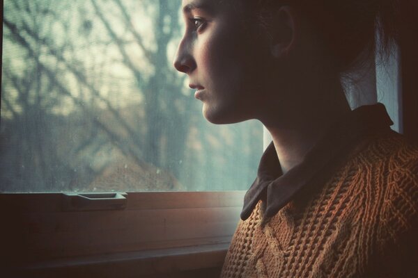 Portrait d une jeune fille regardant par la fenêtre