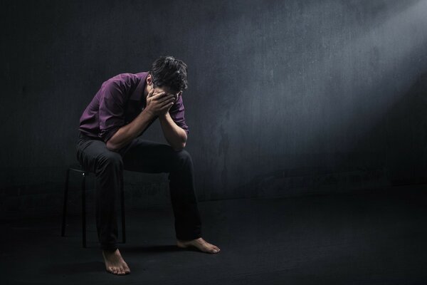 Image of a seated man on a black background