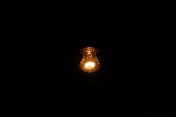 Dim light bulb on a black background electricity