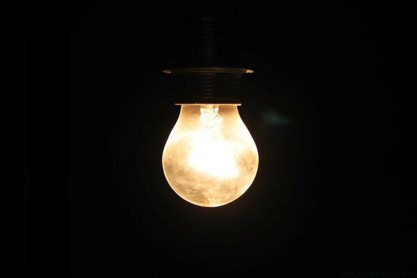 A lonely light bulb is burning in the dark