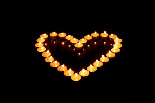 Corazón romántico de velas en la oscuridad