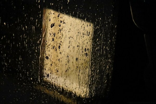 Lluvia fuera de la ventana. Luz detrás del cristal