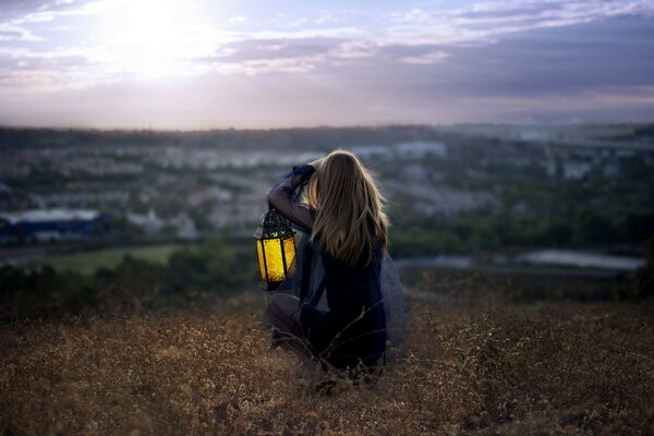 A girl with a lantern takes pictures of the landscape