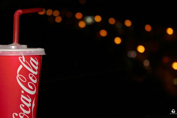 Leuchtend rote Getränkebecher auf dunklem Hintergrund mit Blendung