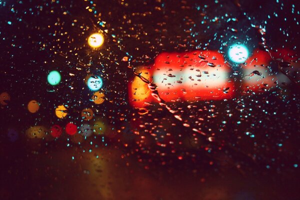 Raindrops on the glass in the light of lanterns