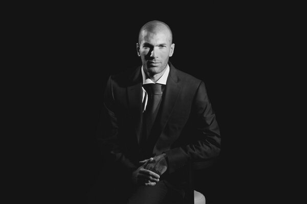 Zidane im klassischen Anzug auf dunklem Hintergrund