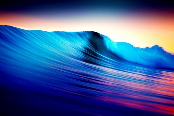 The sea swirls a wave at sunset