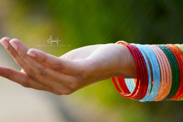 A woman s hand with multicolored bracelets and letters