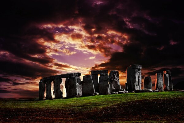 Pôr do sol um campo sobre Stonehenge