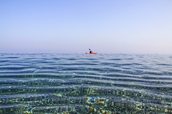 Человек в каноэ плавает в море