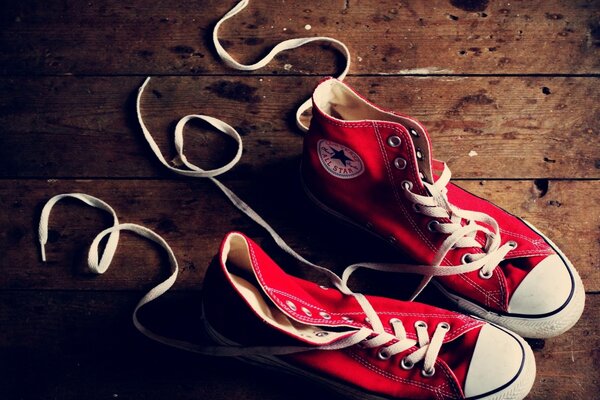 Red sneakers on a wooden background and an inscription made of laces 365