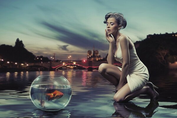 Una chica con un acuario en el fondo de un hermoso paisaje