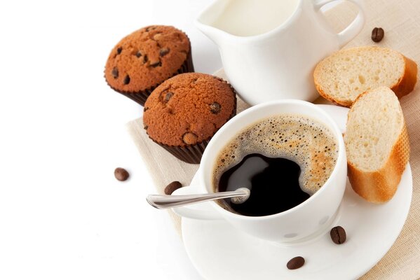 Café negro fuerte en una taza blanca con muffins y pan blanco