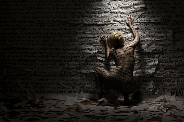 A girl covered with inscriptions near the wall