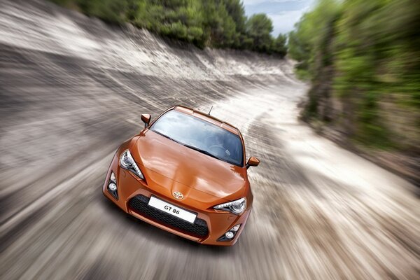 Orange Auto beschleunigt auf der Straße