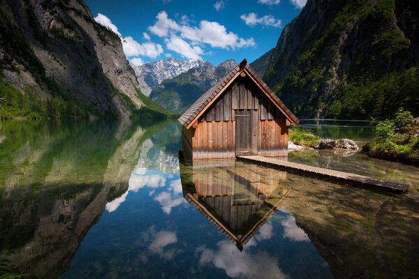 Haus am See vor dem Hintergrund der Berge