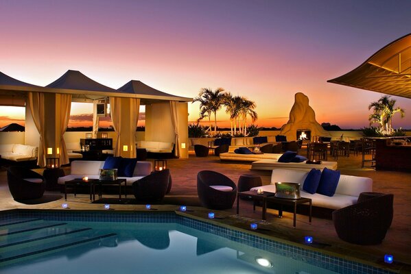 Hotel mit Pool im Hintergrund des Sonnenuntergangs