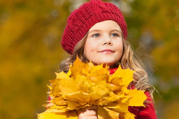 Cute Little Red Riding Hood and a bouquet of leaves