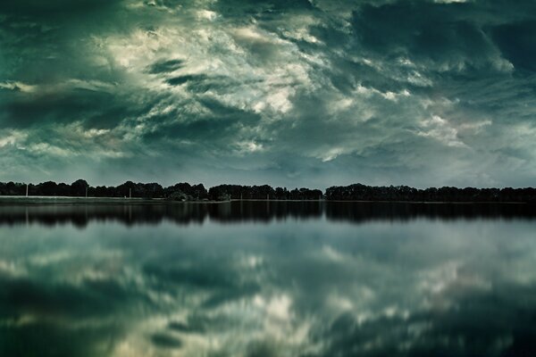 Reflection of the forest in a deep lake at dusk