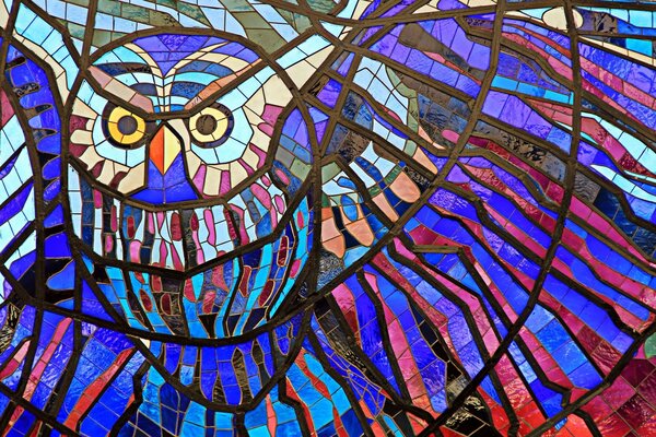 Multicolored stained glass window with the image of a flying owl