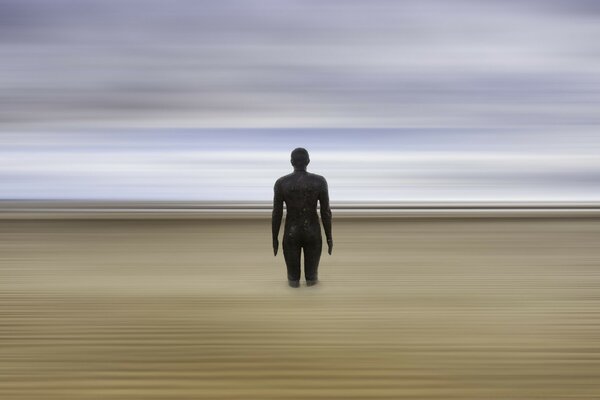 The figure of a man walking on the sand