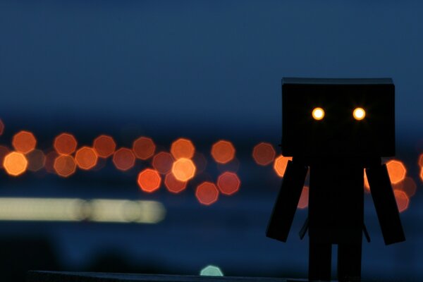 Silhouette of a robot with glowing eyes on a blurry background with highlights