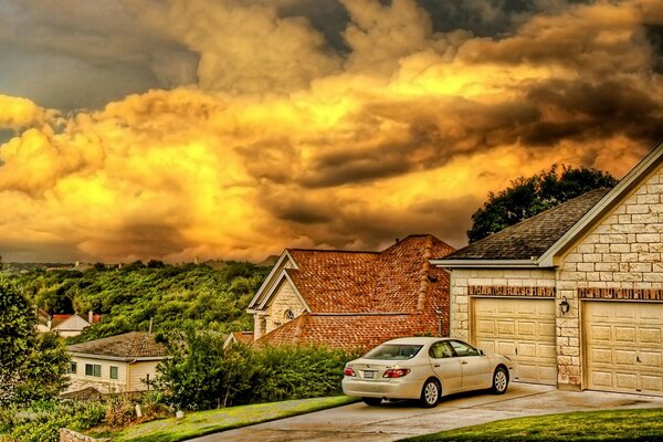 The car is near the house on the hill