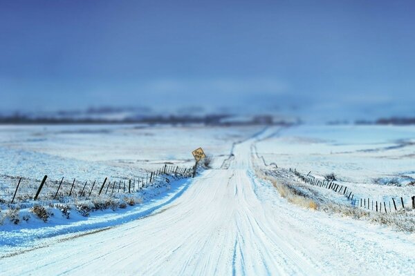 Snowy road through the desert field