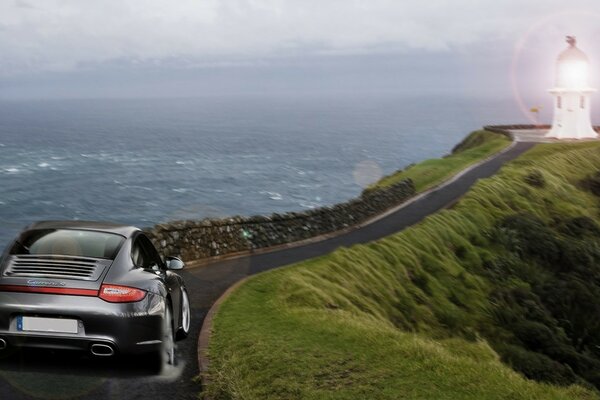 The car is driving along the road to the lighthouse