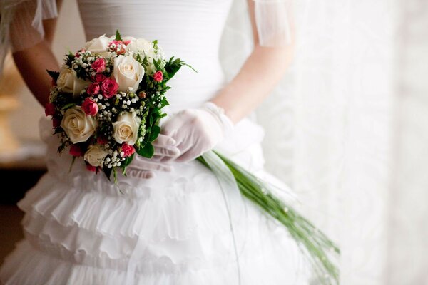 Wedding dress for the bride and a bouquet of white roses