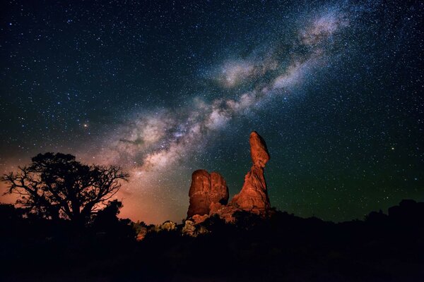 Hermosa roca en el fondo del cielo estrellado. Semilla de noche