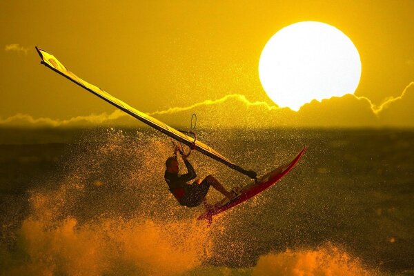 Surfing. Jasny Zachód słońca. Niebiosa. Bryzg