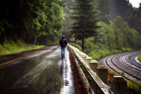 Hombre en medio de un camino mojado