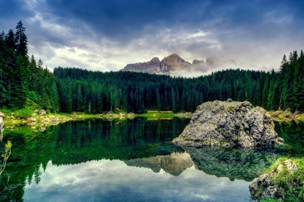 Taiga lake with a beautiful reflection and a stone in the center