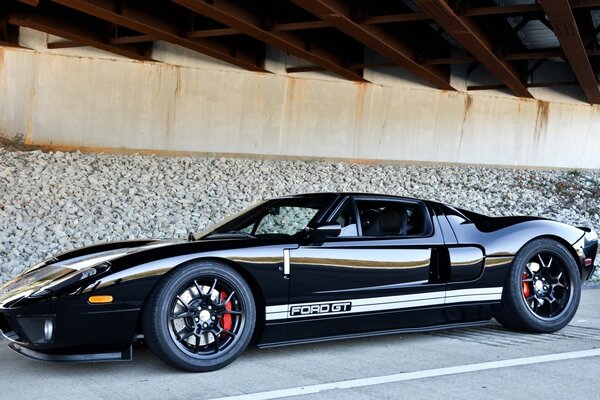 Sports black car on the road by the wall under the roof