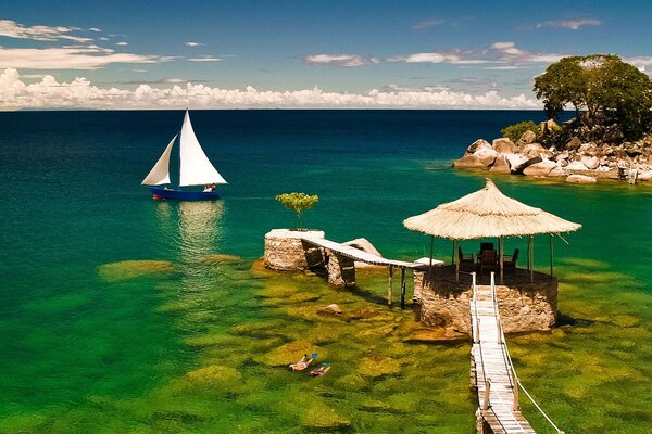 Sailboat tree and stone islands among turquoise water