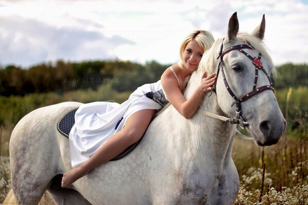 A woman riding a white horse