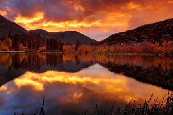 Feuriger Sonnenuntergang spiegelt sich im Wasser wider