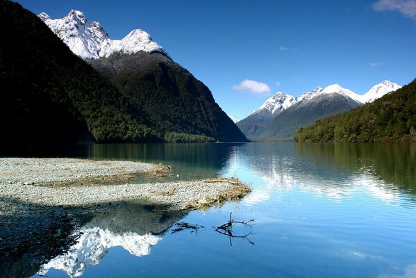 Lago, y alrededor de la montaña con copas de nieve