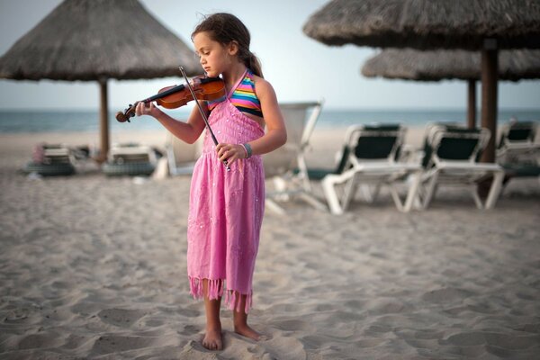 Fille avec violon sur la plage