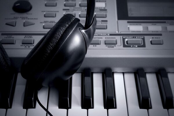 The headphones are on the keyboard of the synthesizer