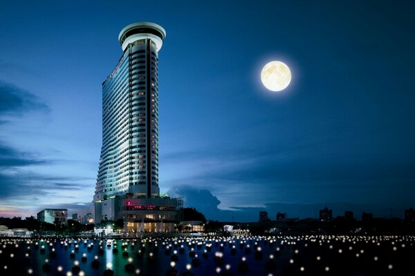 City skyscraper on the background of a full moon