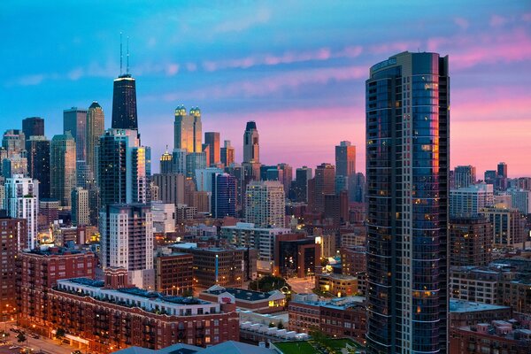 Megapolis with high-rise buildings on the background of pink dawn sky