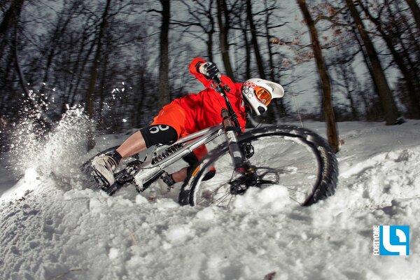 A cyclist drifts in the snow in winter